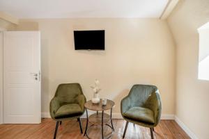 two green chairs and a table in a room at Alte Stadtvilla Weinberg 5 in Traben-Trarbach