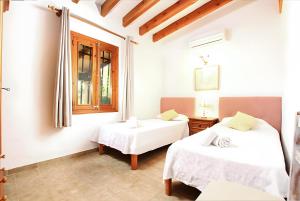a bedroom with two beds and a window at Villa Barraca in Pollença +13 photos