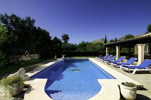 a swimming pool with lounge chairs next to a house at Villa Barraca in Pollença