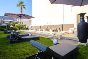 a group of chairs and tables with an umbrella at Maison boutique At Pietro in San Pietro in Lama