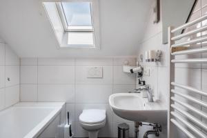 a white bathroom with a sink and a toilet at Fewo Cheny 2 mit 36qm in Titisee-Neustadt +15 photos