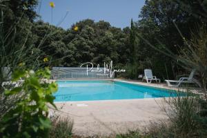 a swimming pool in a yard with two chairs at Gite Domaine Viticole, Pellerin in Montbrison-sur-Lez