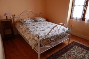 a bed with a metal frame in a bedroom at Gîte Chez Claudette in Briord