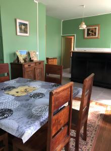 a dining room with a table and chairs and a piano at Gîte Chez Claudette in Briord