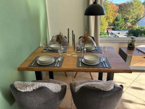 a wooden table with plates and wine glasses on it at Tannenblick in Schönwald +9 photos