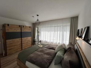 a bedroom with a large bed in front of a window at Tannenblick in Schönwald