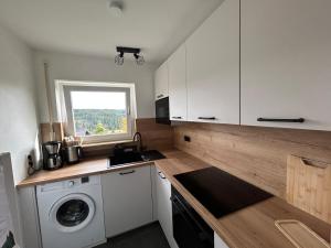 a kitchen with a washing machine and a window at Tannenblick in Schönwald