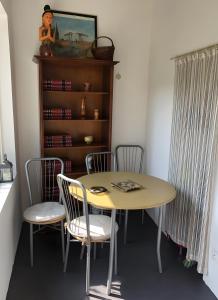 a table and chairs in a room with a book shelf at Gîte Chez Claudette in Briord +19 photos