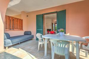 a living room with a table and chairs and a couch at Il Sarago in Marina di Campo