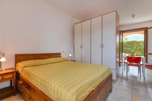 a bedroom with a bed and a table and a window at Il Sarago in Marina di Campo