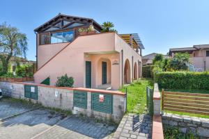 a house with green doors and a fence at Il Sarago in Marina di Campo