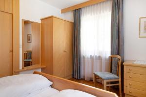 a bedroom with a bed and a dresser and a window at Mayr Apartments Eins in Plaus