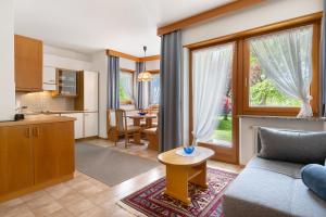 a kitchen and a living room with a couch and a table at Mayr Apartments Eins in Plaus