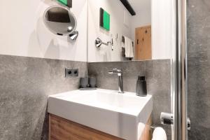 a bathroom with a white sink and a mirror at Residence Skutial Santner Deluxe in Castelrotto +24 photos