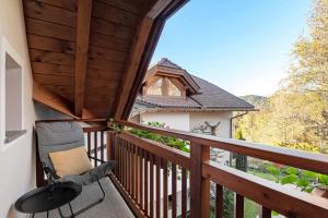 a balcony with a chair and a view of a house at Residence Skutial Santner Deluxe in Castelrotto