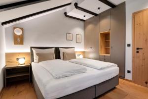 a bedroom with a large white bed and a wooden floor at Residence Skutial Santner Deluxe in Castelrotto