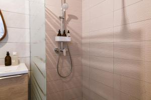 a shower with a shower head in a bathroom at Chez Flo - clim parking - clg in Saint-Pierre-dʼAlbigny
