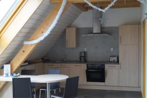 a kitchen with a table and a kitchen with a ceiling at Gîtes du Taennchel in Thannenkirch