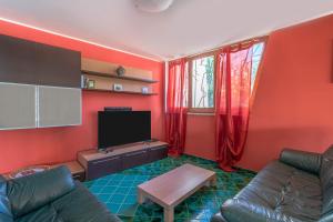 a living room with a couch and a tv at Bes Beach - Villa con piscina in Fontane Bianche
