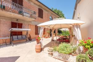 a patio with an umbrella and a table at Casa San Francesco Rapolano in Rapolano Terme