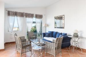 a living room with a blue couch and chairs at Li Conchi 34 in Castiadas