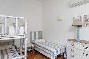 a bedroom with two bunk beds and a dresser at Li Conchi 34 in Castiadas +24 photos