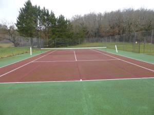 a tennis court with a net on it at Chalet paisible à Mauroux in Mauroux
