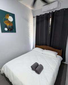 a bedroom with a white bed with two towels on it at Kanvas 21 in Jerantut