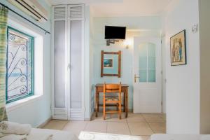 a room with a table and a chair and a window at Family apartment in Corfu