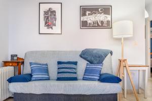 a living room with a gray couch with blue pillows at Brisa y Mar in Calahonda +20 photos