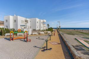 a playground on the beach next to a building at Brisa y Mar in Calahonda
