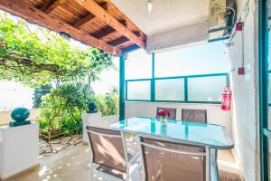 a patio with a table and chairs and a window at Family apartment in Corfu