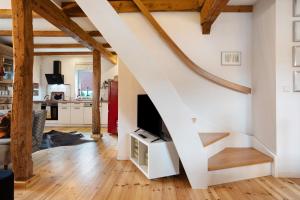 a living room with a tv and a staircase at Peene Hus in Hohen Demzin