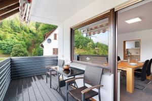 a balcony with a table and chairs and a window at Haus Erika Ferienwohnung 1 in Bad Teinach-Zavelstein