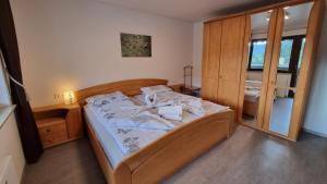 a bedroom with a bed with a wooden headboard at Haus Erika Ferienwohnung 1 in Bad Teinach-Zavelstein