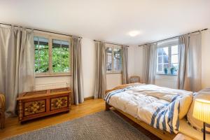a bedroom with a bed and a table and windows at Klosterhof Eggenreute in Wangen im Allgäu