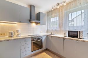 a kitchen with white cabinets and a microwave at Ferienwohnung Am Paradies in Baden-Baden