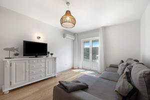 a living room with a couch and a flat screen tv at Casa da Praia in Praia de Odeceixe