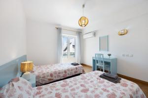 a bedroom with two beds and a window at Casa da Praia in Praia de Odeceixe
