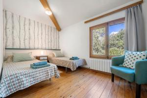 a room with two beds and a chair and a window at Casa Mariti in Mont-ral +34 photos