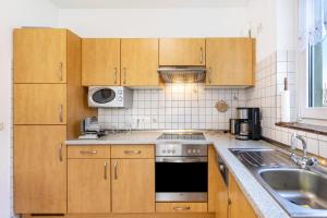 a kitchen with wooden cabinets and a sink and a stove at Ferienhaus Knappstein in Möhnesee