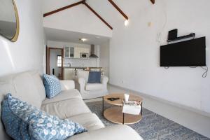 a living room with two white couches and a tv at Los Morros in Punta Mujeres