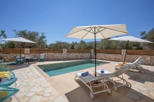 a pool with two chairs and an umbrella and two tables at Zante Villa Amici Loft in Zakynthos