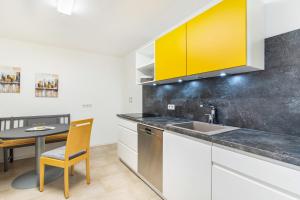 a kitchen with a table and a yellow cabinet at Ferienwohnung Geisbergblick in Seelbach +26 photos