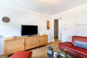a living room with a flat screen tv on a wooden dresser at Ferienwohnung Geisbergblick in Seelbach