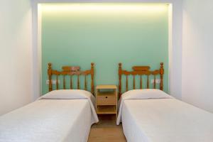 two beds sitting next to each other in a room at Falco 1 in Corralejo +18 photos