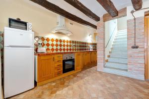a kitchen with a white refrigerator and a staircase at Apartamento con Encanto C in Montroig