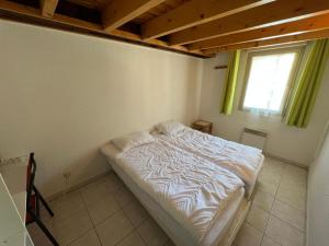 a bedroom with a bed in a room with a window at Charmant Duplex Pied De Pistes in Briançon
