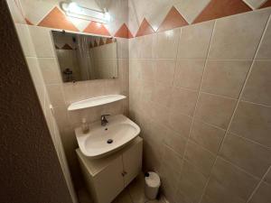 a small bathroom with a sink and a mirror at Charmant Duplex Pied De Pistes in Briançon
