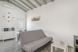 a living room with a couch and a clock on the wall at Casa El Elefante in La Muela